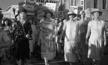 Movie still from “Inherit the Wind” (1960), directed by Stanley Kramer – A black and white photo of a group of people marching down a street; Wide shot, High angle