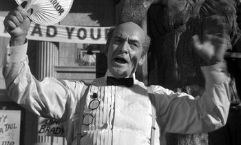 Movie still from “Inherit the Wind” (1960), directed by Stanley Kramer – A man in a suit and bow tie standing next to a tree; Medium shot, Low angle