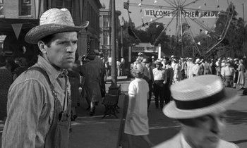 Movie still from “Inherit the Wind” (1960), directed by Stanley Kramer – An old photo of a crowd of people walking down the street; Medium shot, Over the shoulder angle