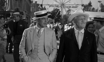 Movie still from “Inherit the Wind” (1960), directed by Stanley Kramer – A couple of men standing next to each other on the street; Medium shot, Low angle
