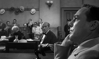 Movie still from “Inherit the Wind” (1960), directed by Stanley Kramer – A black - and - white photo of men sitting in a courtroom; Close Up shot, Over the shoulder angle