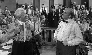 Movie still from “Inherit the Wind” (1960), directed by Stanley Kramer – A group of people in a room with a crowd of people; Medium shot, Over the shoulder angle
