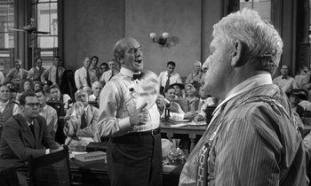 Movie still from “Inherit the Wind” (1960), directed by Stanley Kramer – Two men are standing in front of a group of people; Medium shot, Over the shoulder angle