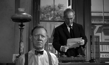 Movie still from “Inherit the Wind” (1960), directed by Stanley Kramer – A man in a suit and tie standing next to another man in a suit and tie; Medium shot, Low angle