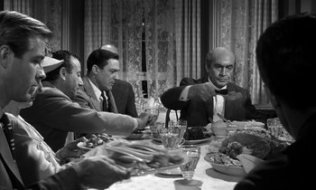 Movie still from “Inherit the Wind” (1960), directed by Stanley Kramer – A black and white photo of people sitting at a dinner table; Medium shot, High angle