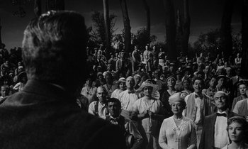 Movie still from “Inherit the Wind” (1960), directed by Stanley Kramer – A group of men and women standing in front of a crowd of onlookers; Wide shot, High angle