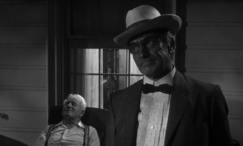 Movie still from “Inherit the Wind” (1960), directed by Stanley Kramer – An old man sitting next to a man wearing a hat; Medium shot, Over the shoulder angle