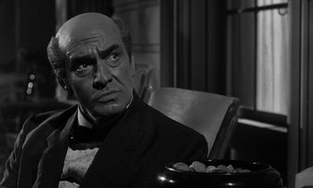 Movie still from “Inherit the Wind” (1960), directed by Stanley Kramer – An old photo of a man in a suit and bow tie; Close Up shot, Over the shoulder angle