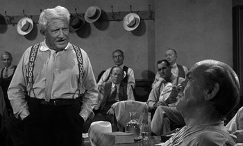 Movie still from “Inherit the Wind” (1960), directed by Stanley Kramer – An older man standing in front of a group of men; Medium shot, Over the shoulder angle