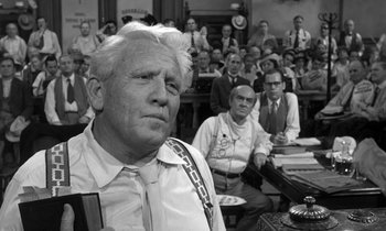 Movie still from “Inherit the Wind” (1960), directed by Stanley Kramer – An older man in a courtroom with a crowd of people watching; Medium shot, Low angle