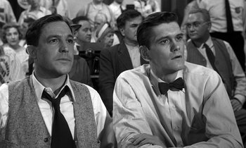 Movie still from “Inherit the Wind” (1960), directed by Stanley Kramer – A black - and - white photo of two men sitting next to each other; Medium shot, Low angle