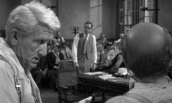 Movie still from “Inherit the Wind” (1960), directed by Stanley Kramer – An old photo of people in a courtroom; Medium shot, Over the shoulder angle