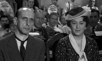 Movie still from “Inherit the Wind” (1960), directed by Stanley Kramer – A black and white photo of a man and a woman in front of an audience; Medium shot, Low angle