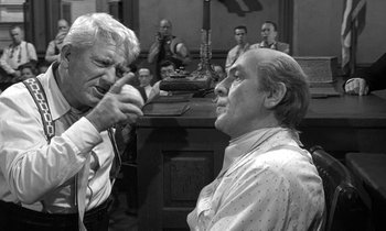 Movie still from “Inherit the Wind” (1960), directed by Stanley Kramer – Two men in a room with a group of people; Medium shot, Over the shoulder angle