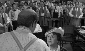 Movie still from “Inherit the Wind” (1960), directed by Stanley Kramer – An old photo of a woman in a crowd of people; Medium shot, Over the shoulder angle