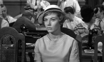 Movie still from “Inherit the Wind” (1960), directed by Stanley Kramer – A woman with a hat sitting in front of a group of people; Close Up shot, Over the shoulder angle