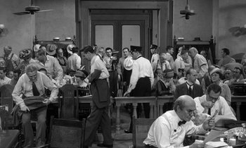 Movie still from “Inherit the Wind” (1960), directed by Stanley Kramer – A group of people standing around a room; Wide shot, High angle