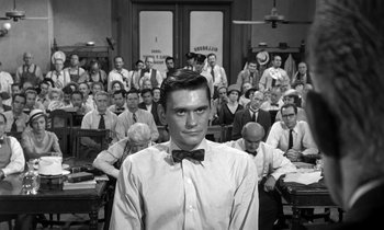 Movie still from “Inherit the Wind” (1960), directed by Stanley Kramer – A man with a bow tie standing in front of a group of people; Medium shot, Over the shoulder angle