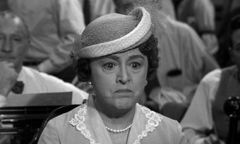 Movie still from “Inherit the Wind” (1960), directed by Stanley Kramer – An old photo of a woman with a hat on; Close Up shot, Over the shoulder angle