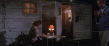 Movie still from “Inside Daisy Clover” (1965), directed by Robert Mulligan – A woman sitting at a table in front of a lamp; Wide shot, High angle