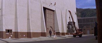 Movie still from “Inside Daisy Clover” (1965), directed by Robert Mulligan – A man and a woman are standing in front of a building; Extreme Wide shot, Low angle