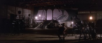 Movie still from “Inside Daisy Clover” (1965), directed by Robert Mulligan – A man sitting in a chair in front of stairs; Extreme Wide shot, High angle