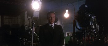 Movie still from “Inside Daisy Clover” (1965), directed by Robert Mulligan – A man in a suit and tie standing in front of lights; Medium shot, Low angle