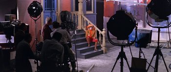 Movie still from “Inside Daisy Clover” (1965), directed by Robert Mulligan – A man dressed as a clown sitting on a set of stairs; Wide shot, High angle