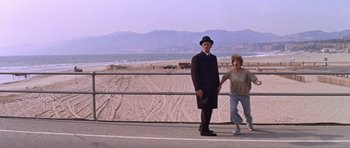 Movie still from “Inside Daisy Clover” (1965), directed by Robert Mulligan – A man and a woman standing on the side of a road; Wide shot, Low angle