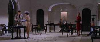 Movie still from “Inside Daisy Clover” (1965), directed by Robert Mulligan – A man sitting at a table in front of a woman; Wide shot, Low angle