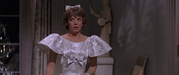Movie still from “Inside Daisy Clover” (1965), directed by Robert Mulligan – A woman in a white dress standing in front of a statue; Medium shot, Over the shoulder angle