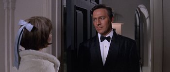 Movie still from “Inside Daisy Clover” (1965), directed by Robert Mulligan – A man and a woman wearing tuxedos in front of a door; Medium shot, Over the shoulder angle