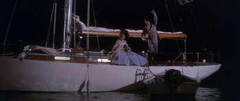 Movie still from “Inside Daisy Clover” (1965), directed by Robert Mulligan – A man and a woman sitting on a sail boat at night; Wide shot, Low angle