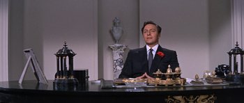 Movie still from “Inside Daisy Clover” (1965), directed by Robert Mulligan – A man sitting at a desk in a suit and tie; Medium shot, Low angle
