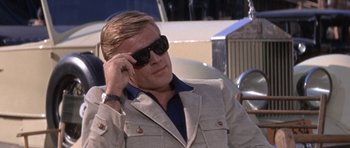 Movie still from “Inside Daisy Clover” (1965), directed by Robert Mulligan – A man in a suit and sunglasses sitting in a car; Close Up shot, Low angle