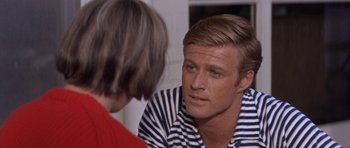 Movie still from “Inside Daisy Clover” (1965), directed by Robert Mulligan – A man in striped shirt talking to another man; Close Up shot, Over the shoulder angle