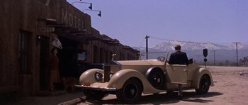 Movie still from “Inside Daisy Clover” (1965), directed by Robert Mulligan – An old car is driving down the street; Wide shot, Low angle