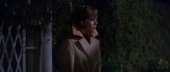 Movie still from “Inside Daisy Clover” (1965), directed by Robert Mulligan – A woman in a brown coat standing in front of a tree; Medium shot, Low angle