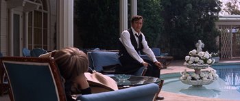 Movie still from “Inside Daisy Clover” (1965), directed by Robert Mulligan – A man sitting on top of a couch next to a woman; Medium shot, Over the shoulder angle