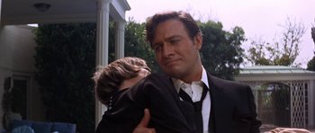 Movie still from “Inside Daisy Clover” (1965), directed by Robert Mulligan – A man in a suit and tie holding a young boy; Close Up shot, Low angle