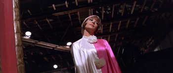 Movie still from “Inside Daisy Clover” (1965), directed by Robert Mulligan – A woman in a pink and white dress stands in front of an audience; Medium shot, Low angle