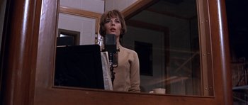 Movie still from “Inside Daisy Clover” (1965), directed by Robert Mulligan – A woman standing in front of a microphone in a room; Medium shot, Low angle