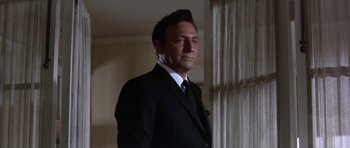 Movie still from “Inside Daisy Clover” (1965), directed by Robert Mulligan – A man in a suit and tie standing in front of a window; Close Up shot, Low angle