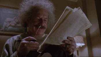 Movie still from “Insignificance” (1985), directed by Nicolas Roeg – An older man is reading a newspaper; Medium shot, Low angle