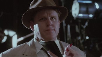 Movie still from “Insignificance” (1985), directed by Nicolas Roeg – A man wearing a hat and a tie with a cigarette in his mouth; Close Up shot, Low angle