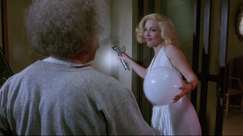 Movie still from “Insignificance” (1985), directed by Nicolas Roeg – A woman in a white dress holding a white balloon; Medium shot, Over the shoulder angle