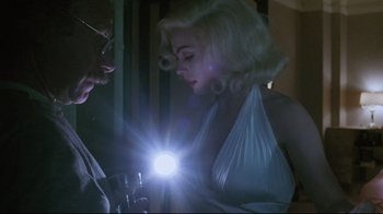 Movie still from “Insignificance” (1985), directed by Nicolas Roeg – A man and a woman are holding a flashlight; Medium shot, Low angle
