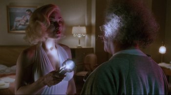 Movie still from “Insignificance” (1985), directed by Nicolas Roeg – An older man and a young woman in a living room; Medium shot, Over the shoulder angle