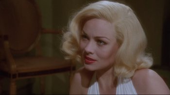 Movie still from “Insignificance” (1985), directed by Nicolas Roeg – A woman with blonde hair sitting in front of a mirror; Close Up shot, Over the shoulder angle