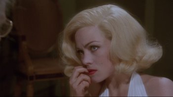 Movie still from “Insignificance” (1985), directed by Nicolas Roeg – A woman with blonde hair and red lipstick looking to her left; Close Up shot, Over the shoulder angle